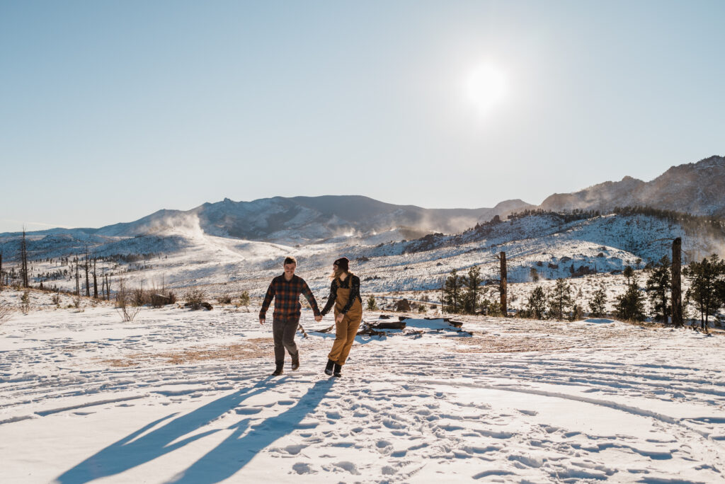 couple running in the snow for their engagement photos