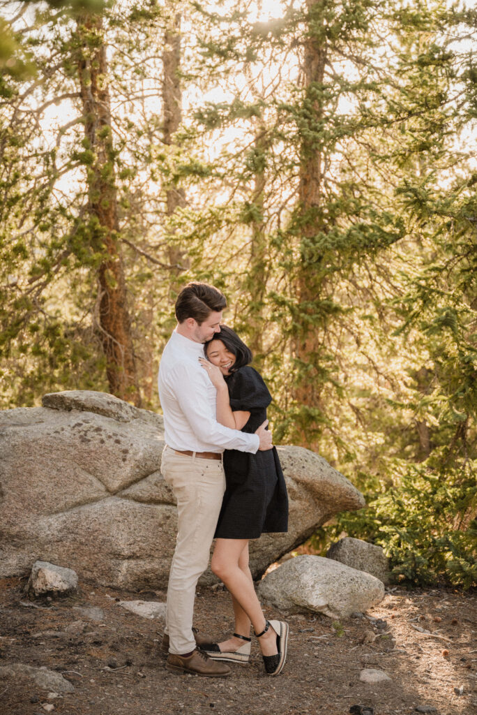 couple hugging and posing in the forest for their engagement photos
