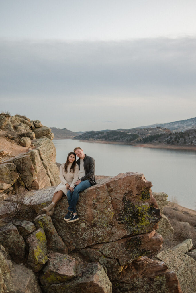 couple posing on a rock for their engagement photos