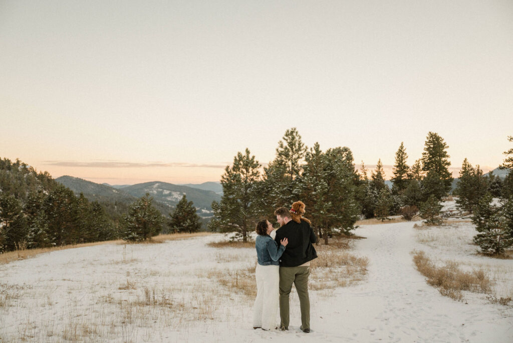 couple posing on the mountains in colorado for their engagement photos