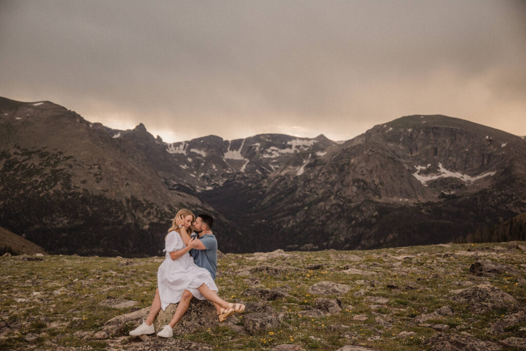 couple sitting in front of the mountains for their engagement photos
