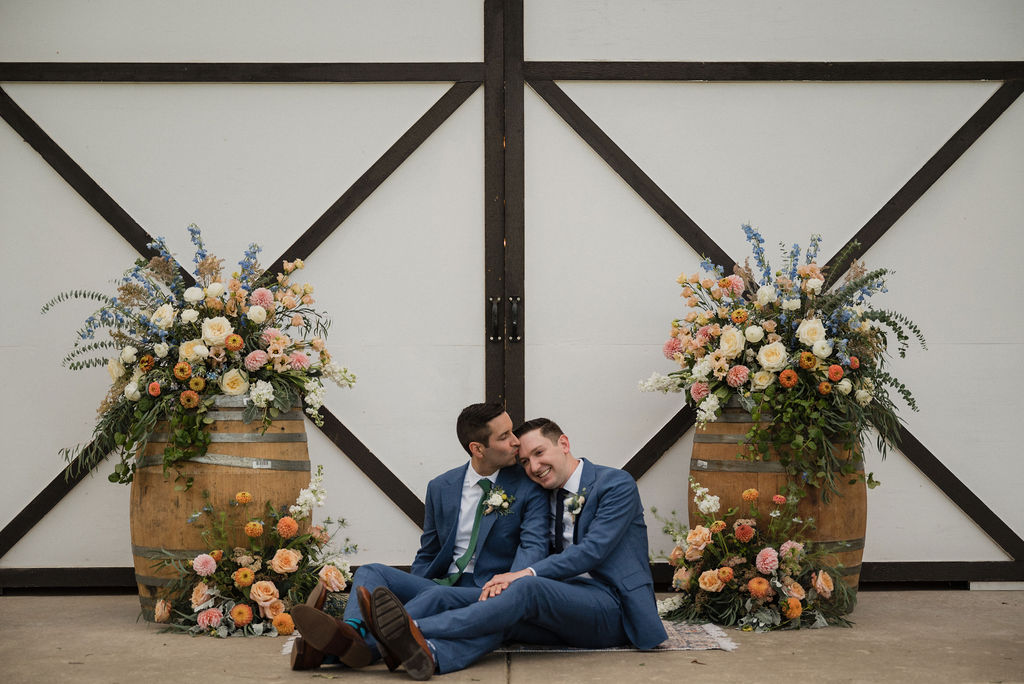 two grooms kissing by their ceremony space